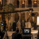 طاقم تصوير درامي عربي يعمل داخل موقع تاريخي مجهز سينمائيًا