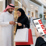 متسوقون يقارنون عروض موسم التخفيضات في مركز تجاري سعودي