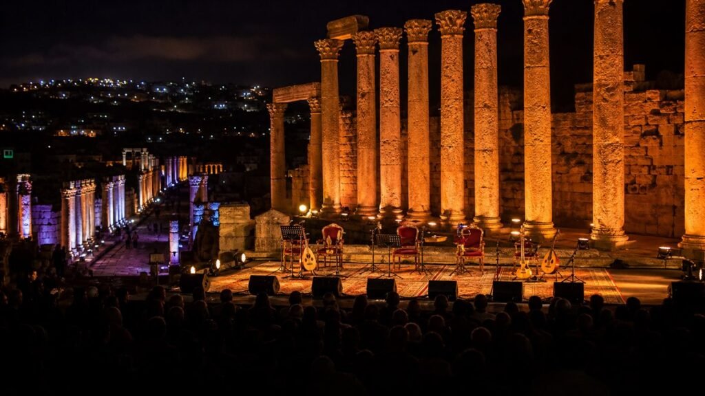 مسرح موسيقي مضاء بين أعمدة جرش الأثرية وآلات عود